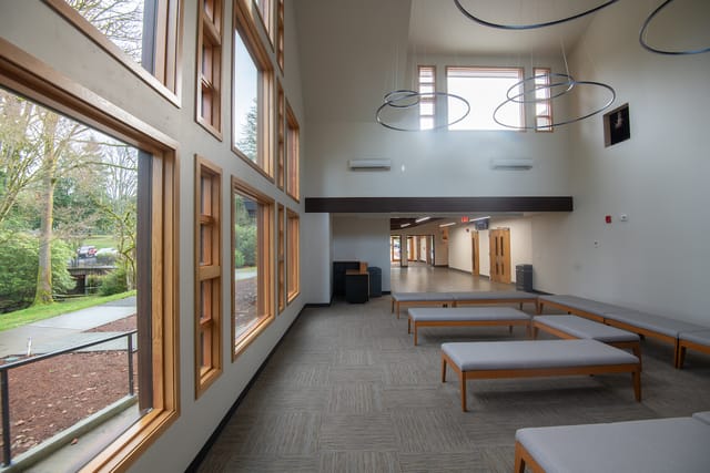 The bright lobby of the new chapel with tall windows and bench seating