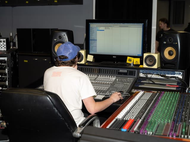 A student works the mixing console in the Creatio Studio recording studio