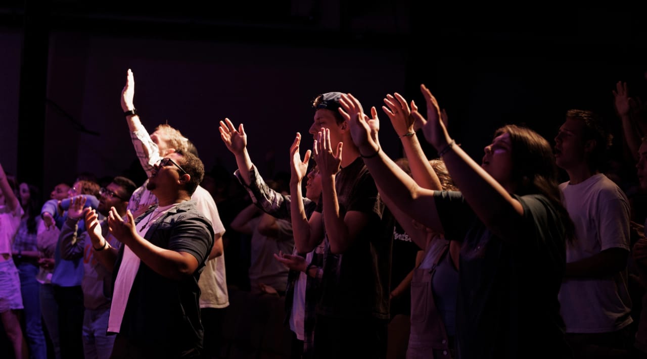 Northwest University students worshipping with raised hands during chapel