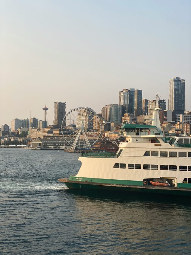 A Washington State ferry crossing Elliott Bay in front of the Seattle skyline and Space Needle